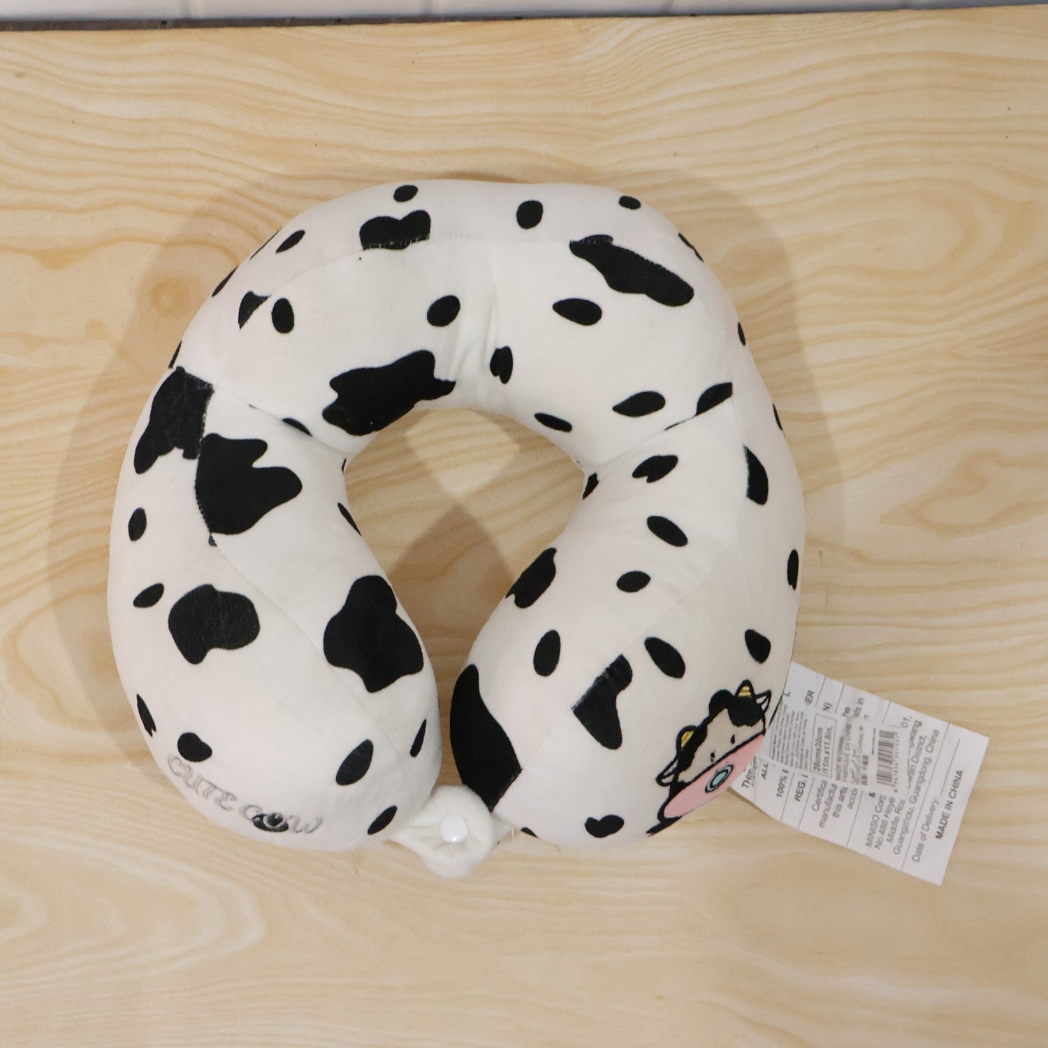 Playful cow print travel neck pillow for restful journeys